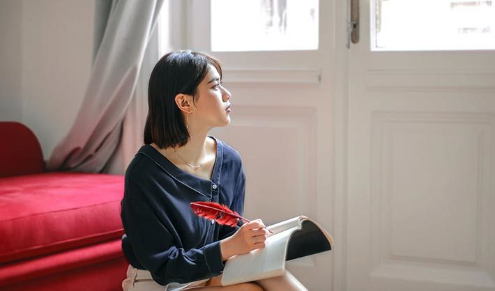 Young woman with notebook looks to the right
