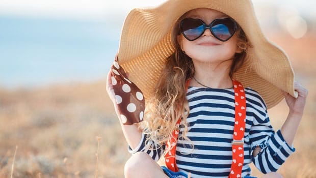 Kid wearing a floppy hat and sunglasses for added sun protection