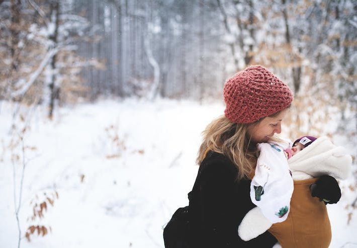 A young woman and a child in a snowy wooded area