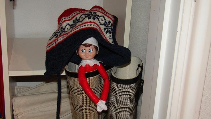 A stuffed toy elf sits in a boot.