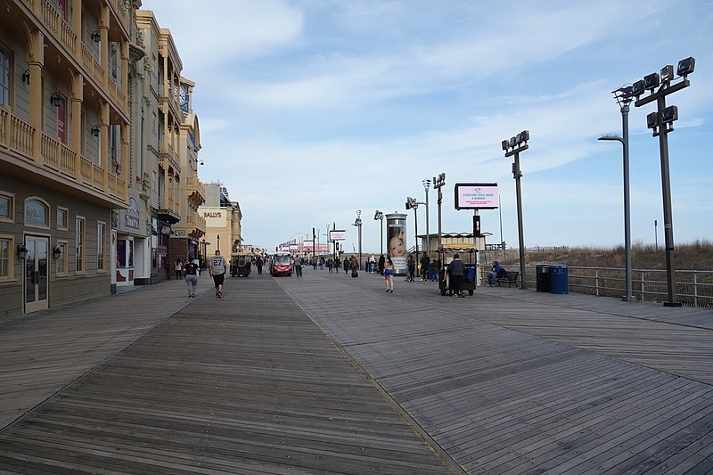 People walk along a beach boardwalk. 