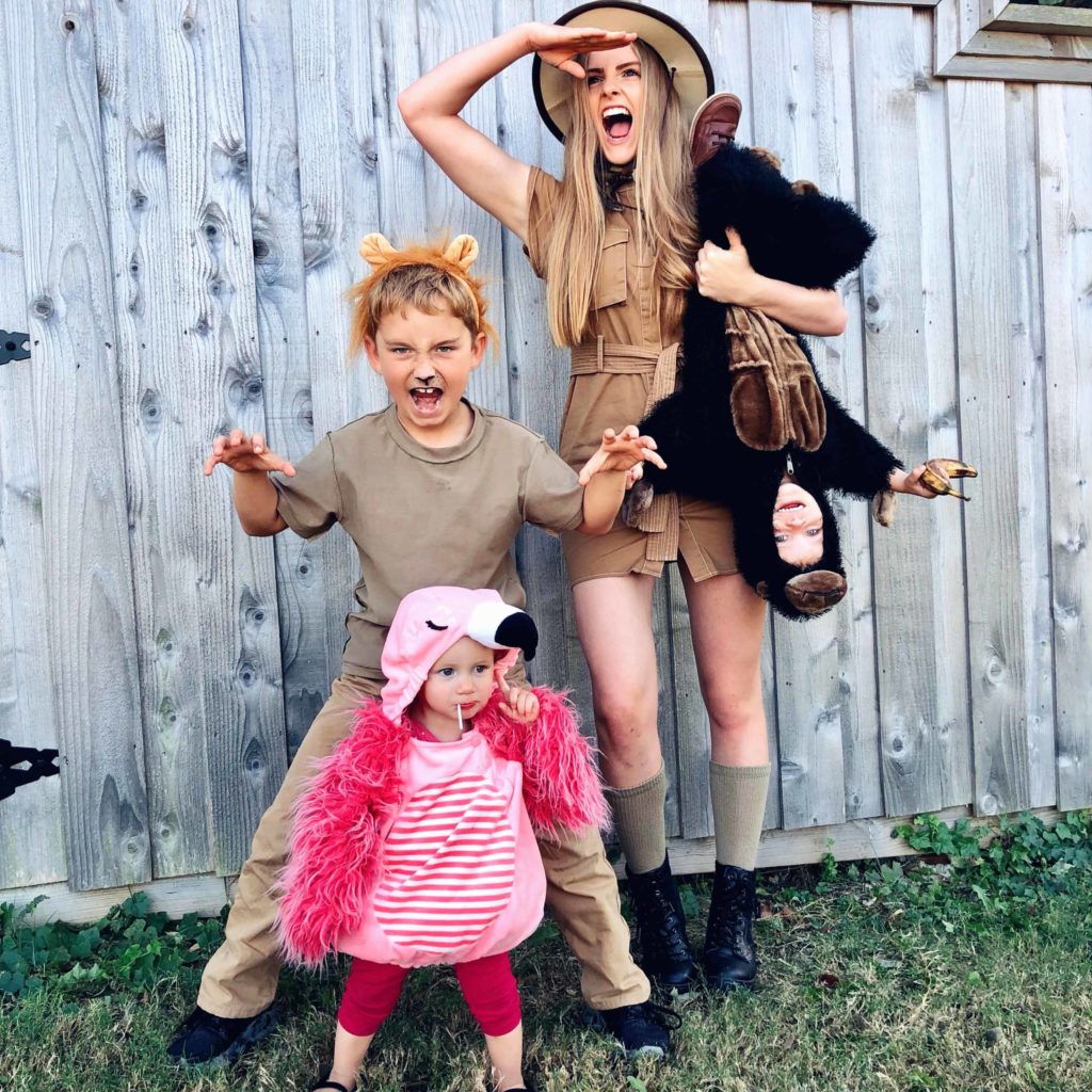 An au pair and her host kids in matching Halloween costumes.