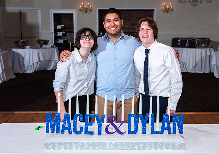 Colombian male au pair poses with two brothers at b'nai mitzvah