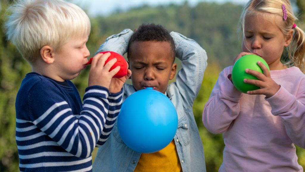 Kids blowing up balloons 