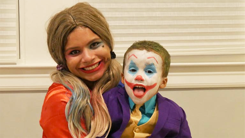 Young woman and young boy in Halloween costumes of Batman's Harley Quinn and the Joker.