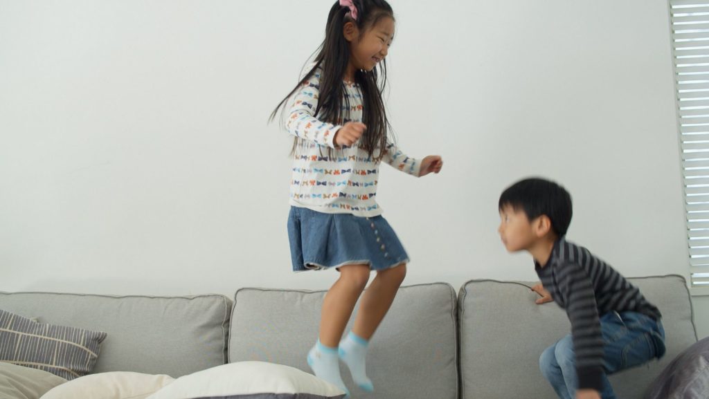 Host children playing Floor is Lava with au pair