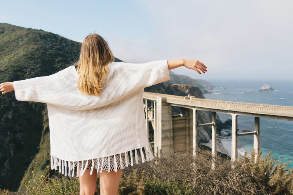 Woman looking at beautiful scenery, arms raised and looking free.