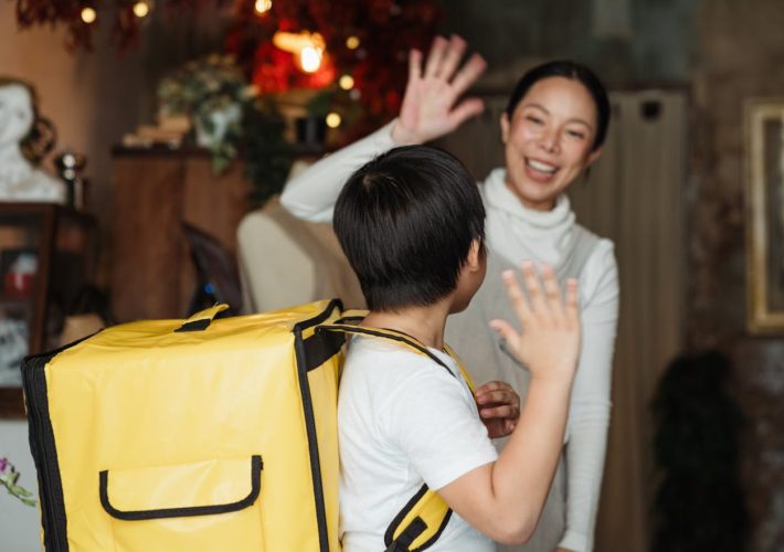 Woman waving goodbye to child.