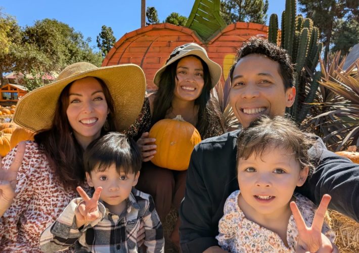 Family and au pair posing in a pumpkin patch