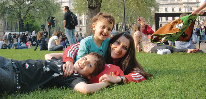 au pair lying in park with host kids