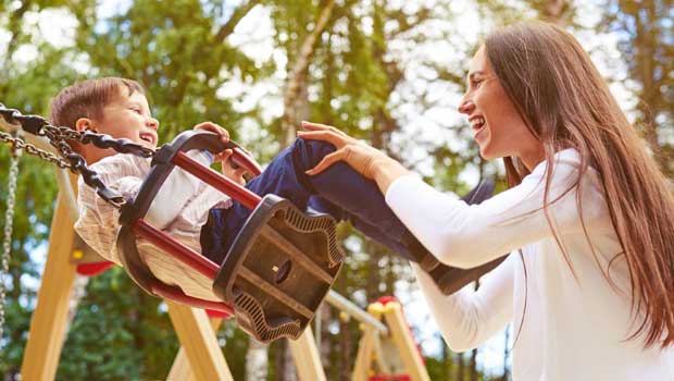 Au pair swinging with child