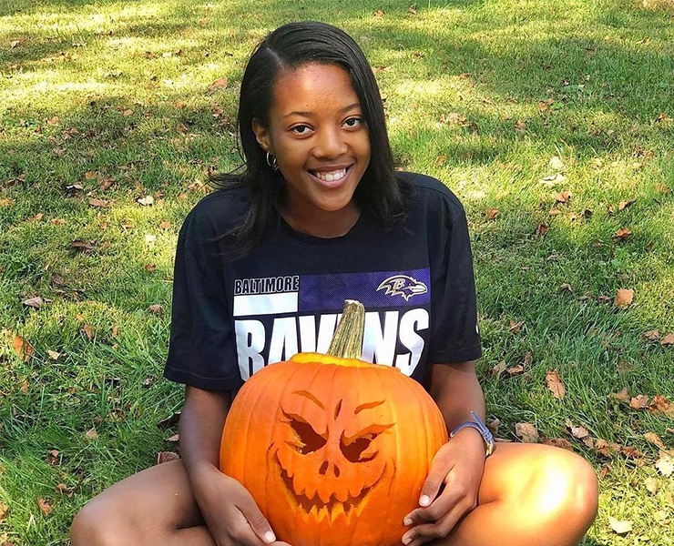 South African au pair holding a carved pumpkin