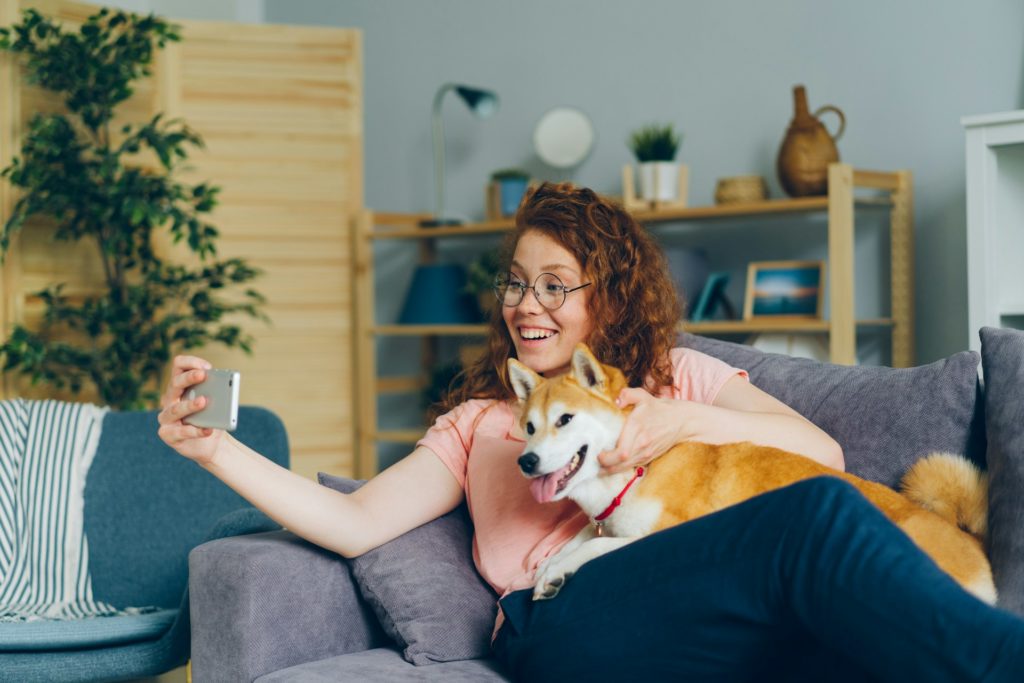 A woman on a couch FaceTiming from her phone. 
